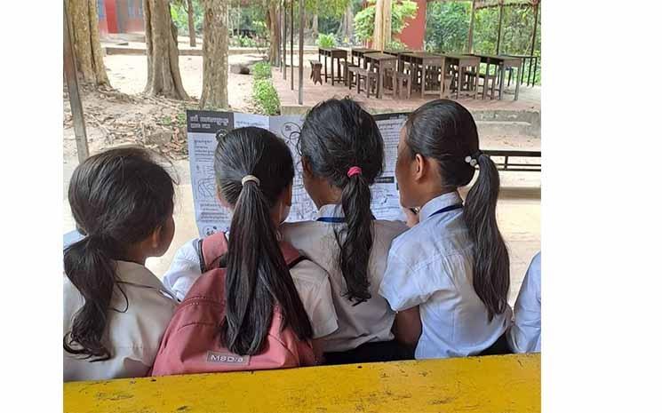 Enfants travaillant avec le magazine Kroojchmar en classe, Ecole du Bayon, Siem Reap.