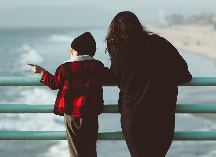 une maman et son enfant regardent au loin sur une digue 