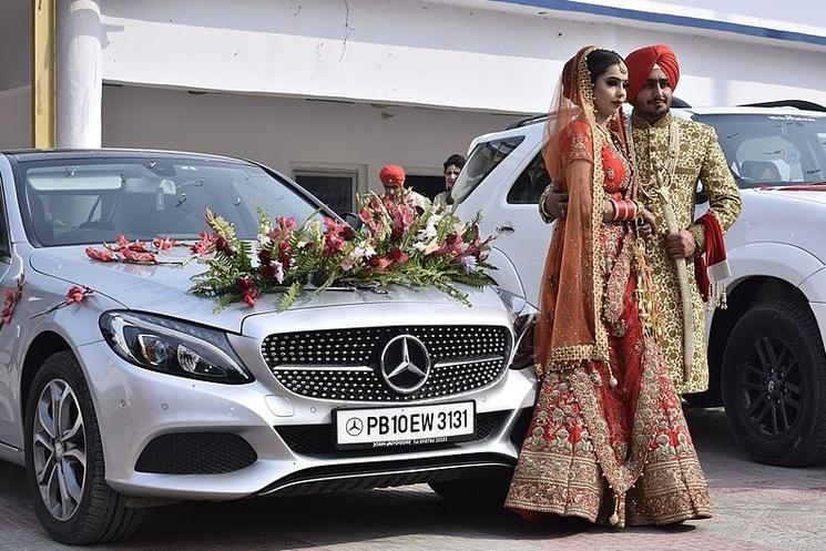 Des mariés indiens posent devant une voiture décorée. Image : Benipal Hardarshan (CC)