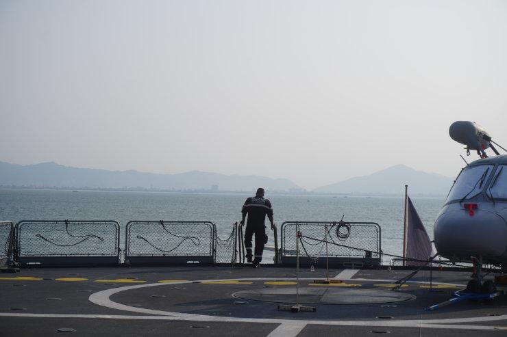 Un représentant de la marine nationale à côté d’un hélicoptère de type Dauphin au Vietnam