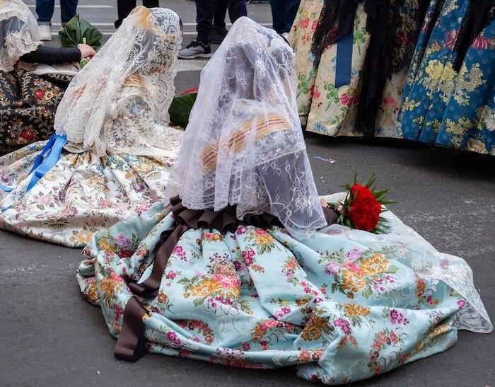 falleras assises avec un voile de dos