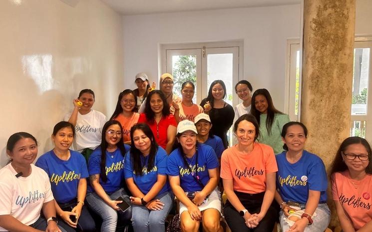 Des femmes regroupées pour une photo de groupe portent le t-shirt Uplifters.