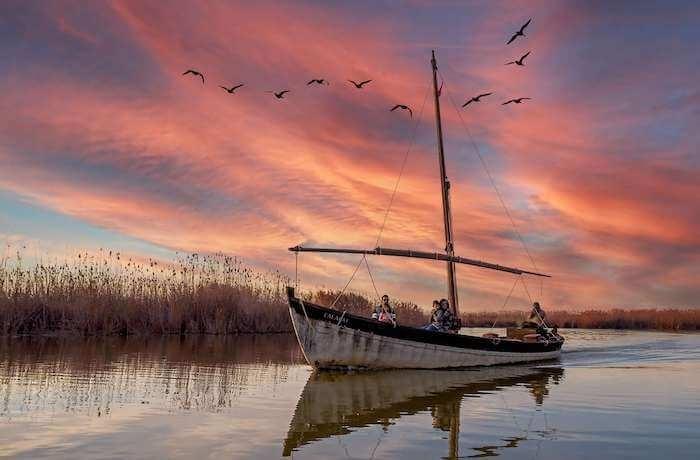 une barque traditionnelle de pécheur sur le lac de l albufera au cocuher du soleil