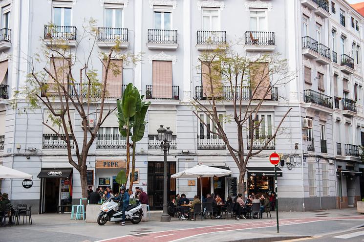 un immeuble gris des arbres et une terrasse