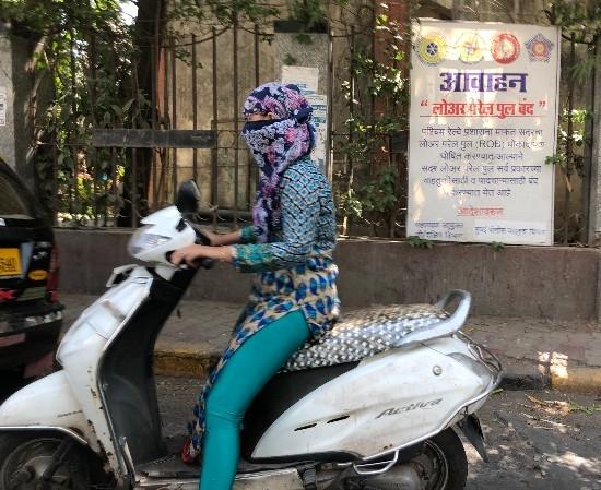 Jeune fille sans casque sur son scooter