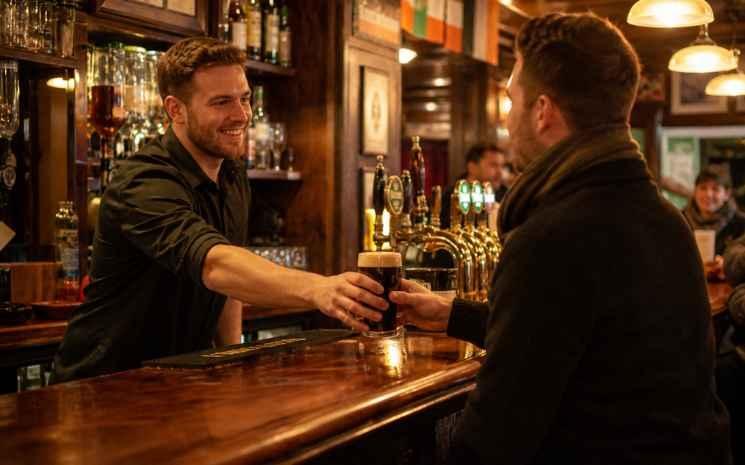 un client se fait servir une pinte au pub en Irlande