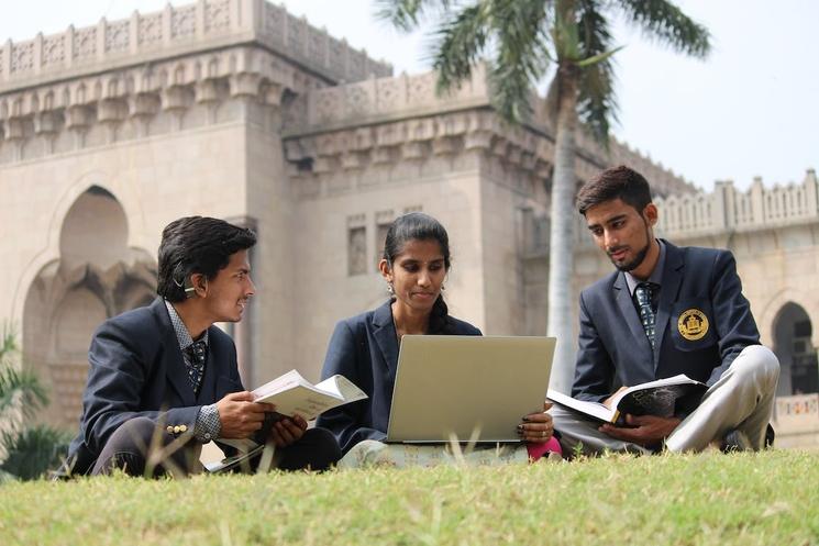 Jeunes indiens en train d'étudier devant leur université.