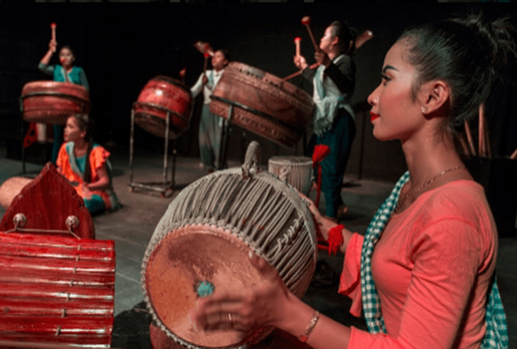 Membre du groupe jouant le tambour traditionnel