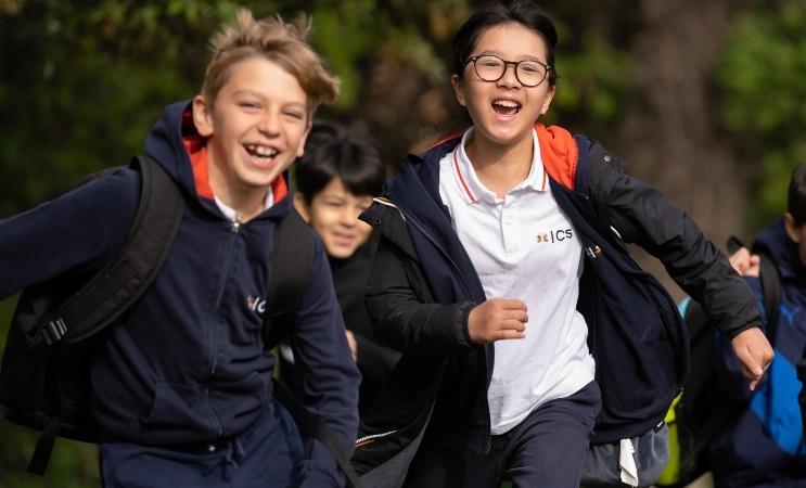 trois enfants en uniforme bleu marine courent