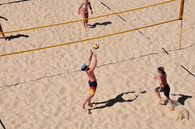 des personnes en train de jouer au volleyball sur la plage