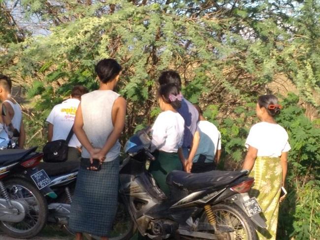 Des badauds apres l'agression d'une institutrice en Birmanie