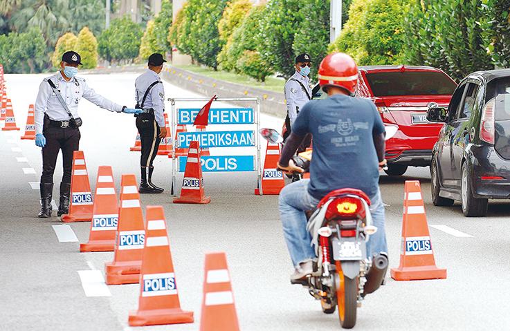Homme en moto devant des autorités malaisienne
