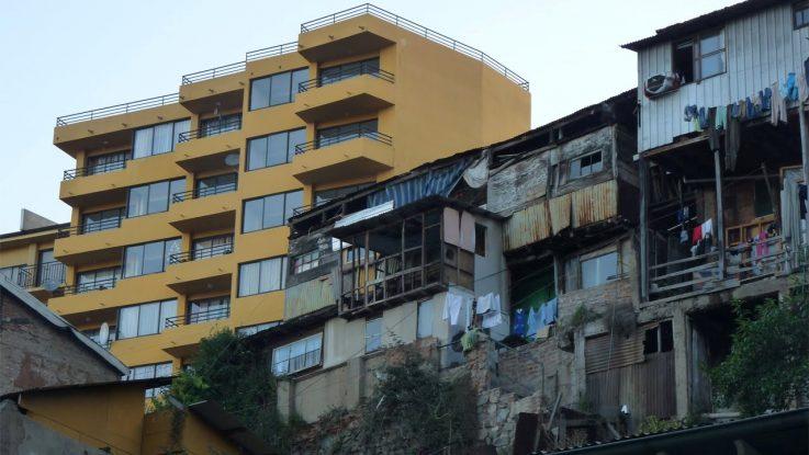 Un immeuble pauvre délabré est à côté d'un autre beau riche