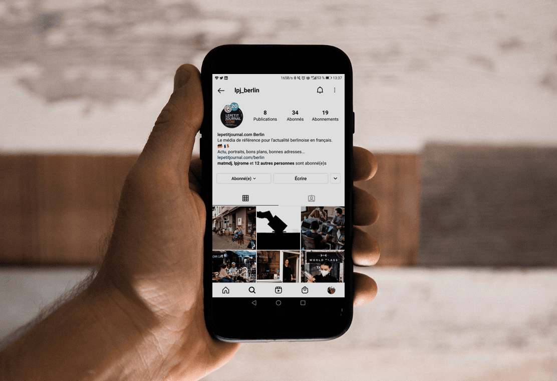 Photo d'une main tenant un téléphone portable affichant la page Instagram du petit journal de Berlin