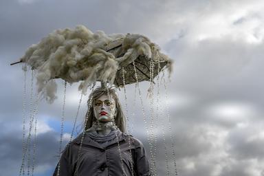 Une sculpture artistique représentant une femme avec un nuage de pluie accroché au-dessus de sa tête