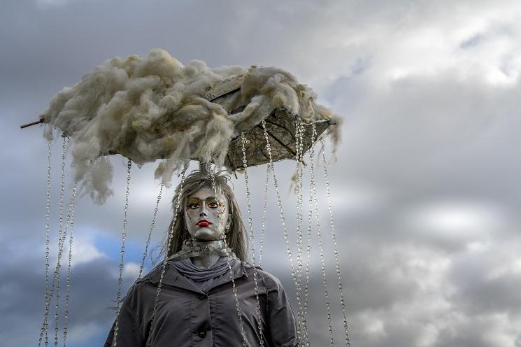 Une sculpture artistique représentant une femme avec un nuage de pluie accroché au-dessus de sa tête