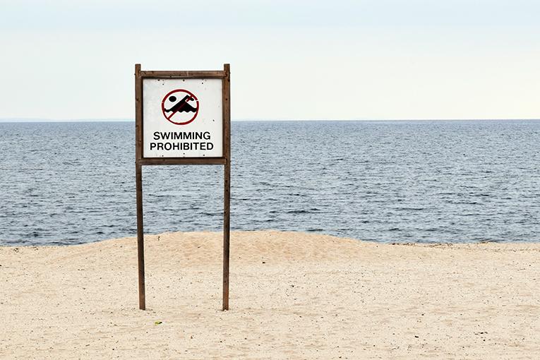 Un panneau baignade interdite sur une plage