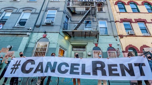 Des personnes tiennent une banderole "annulez les loyers" à New York