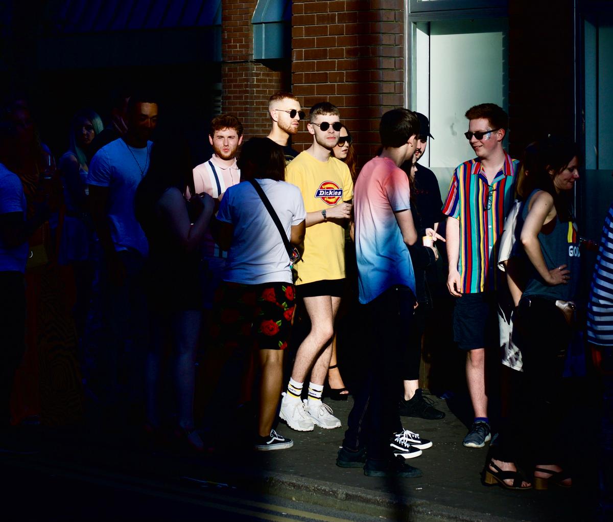des jeunes font la queue devant un bâtiment