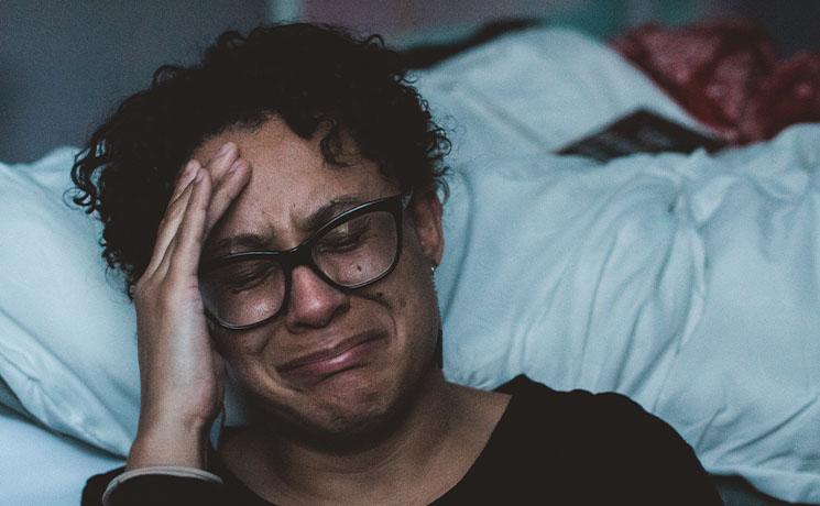 une femme pleure par terre