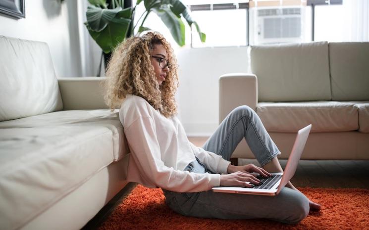 femme tapant à l'ordinateur à la maison