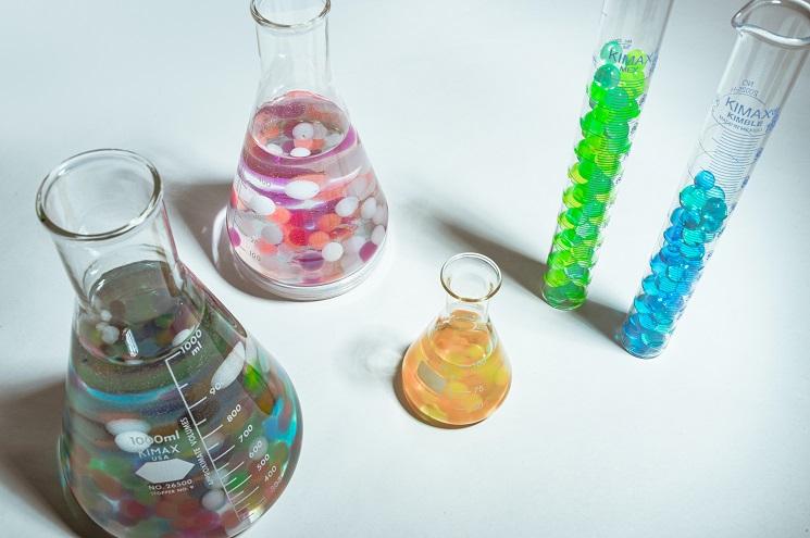 Des contenants de laboratoire remplis de billes colorées