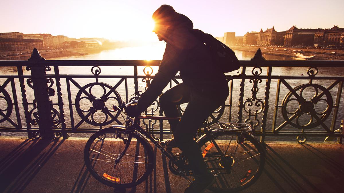Un homme traverse un pont à vélo.