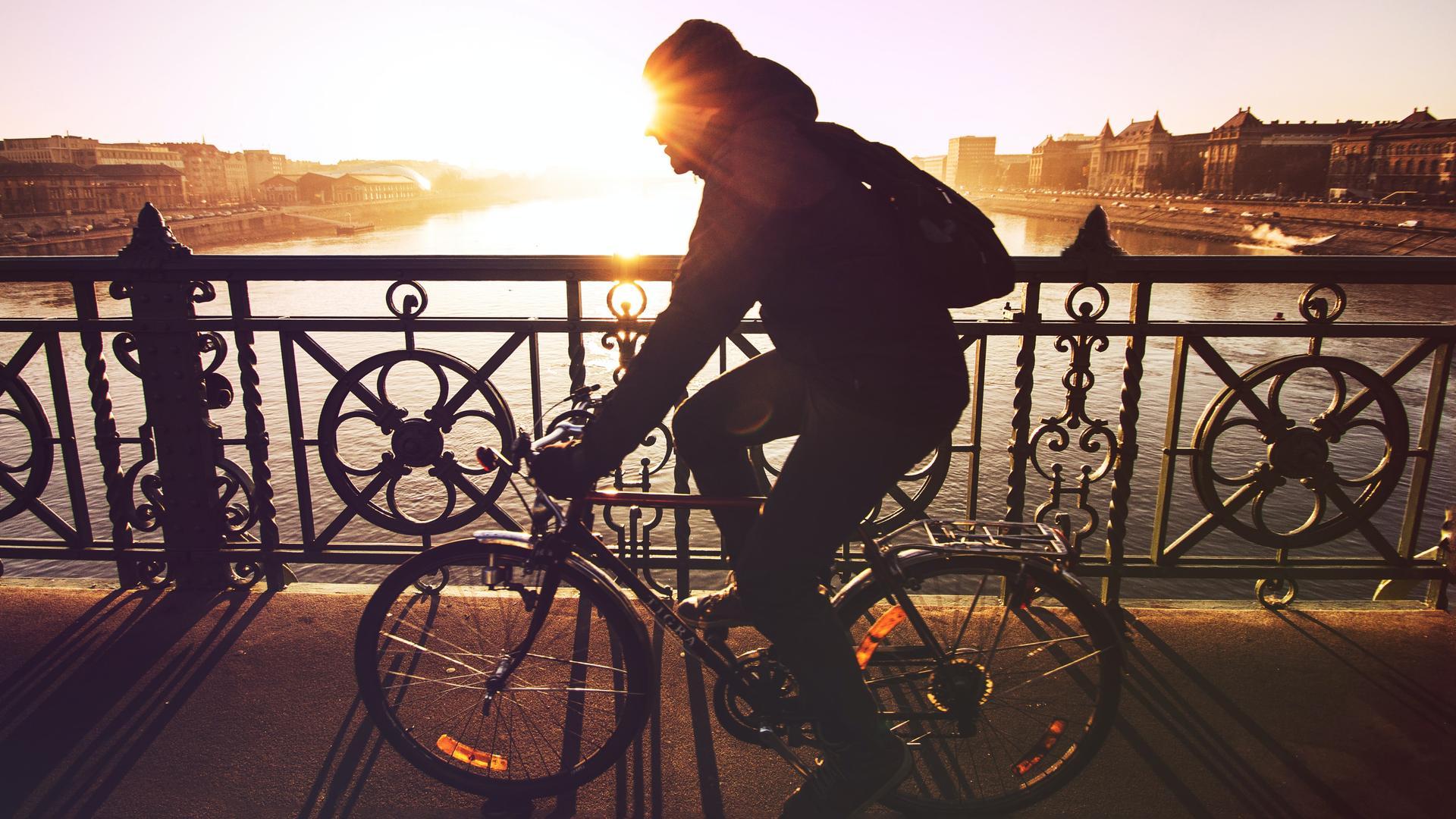 Un homme traverse un pont à vélo.