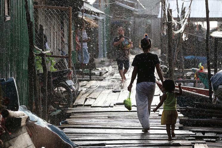 Cambodia_Mother-and-daughther-walk-hand-in-hand-in-the-ran_2013-photo-Karl-Grobl