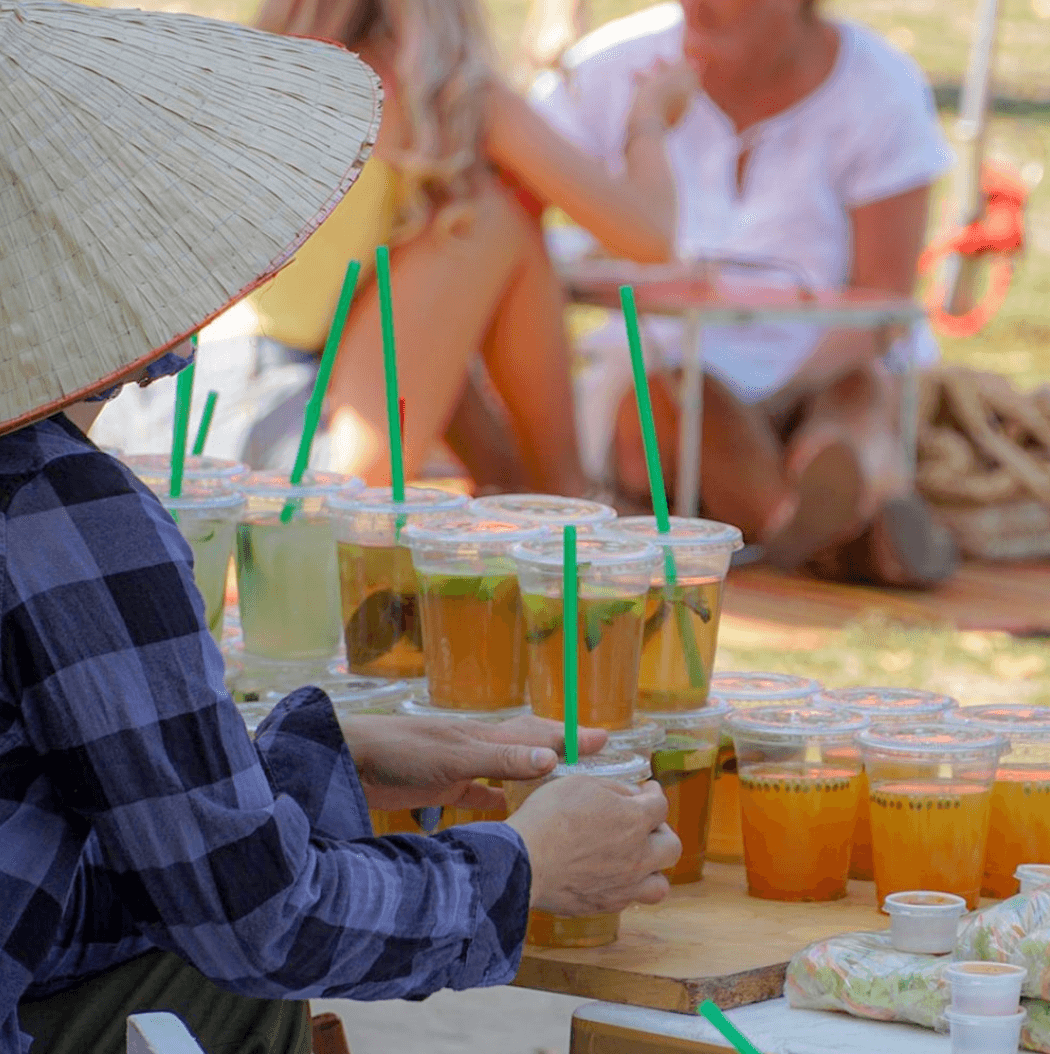 Une personne avec un chapeau asiatique vendant des limonades