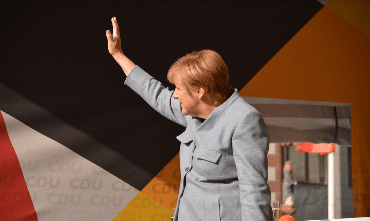 Angela Merkel faisant un signe de la main.