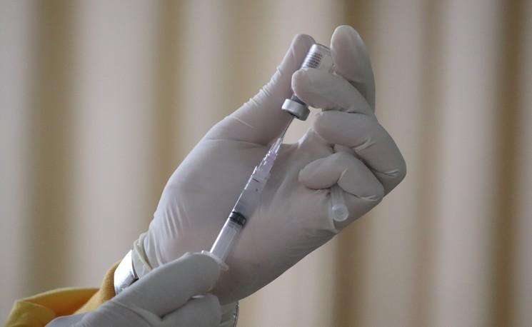 une personne tient un vaccin contre le covid-19 dans sa main
