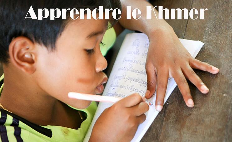 un enfant s'applique à l'écriture