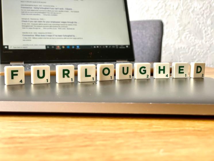 Les lettres du mot furloughed disposées sur un ordinateur portable