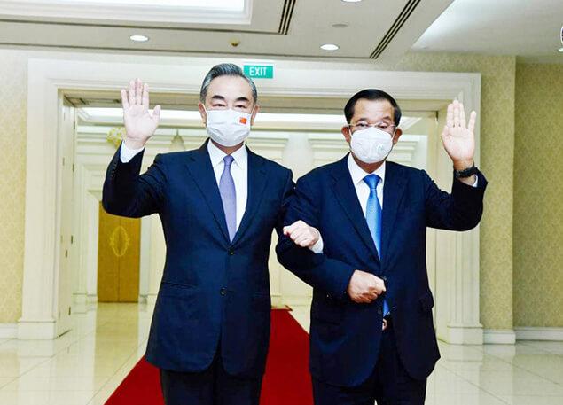Le Premier ministre cambodien Hun Sen pose avec le conseiller d’Etat et ministre des Affaires étrangères de la République populaire de ChineWang Yi
