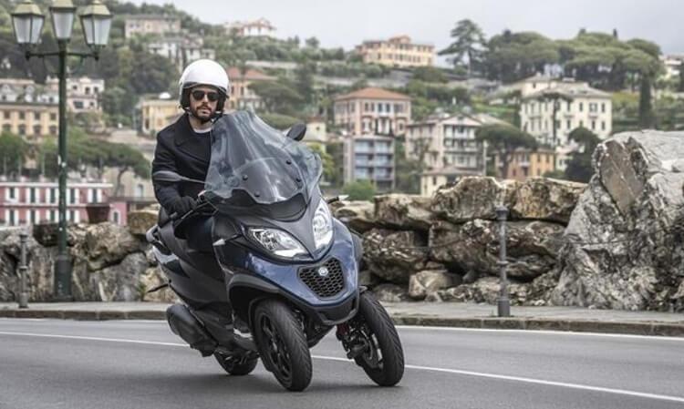 un Scooter trois roues piaggio sur la route