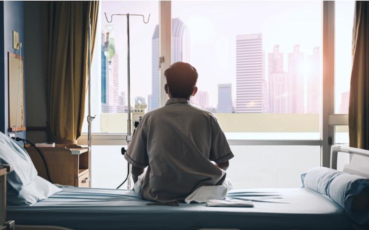 malade dans un hopital devant une fenetre @namtipStudio