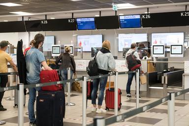 Personnes attendant leur check-in à l'aéroport BER