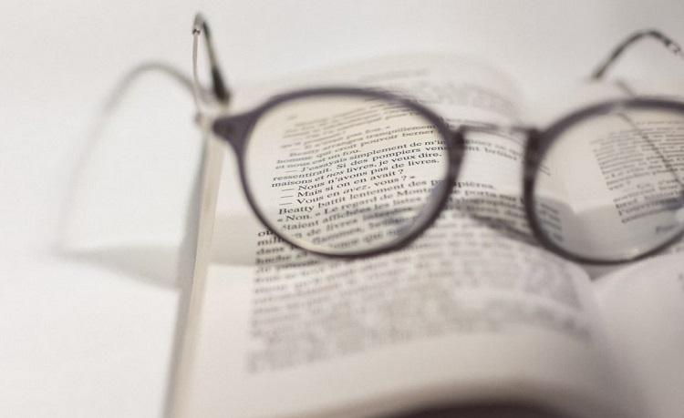 un livre ouvert avec des lunettes posées dessus