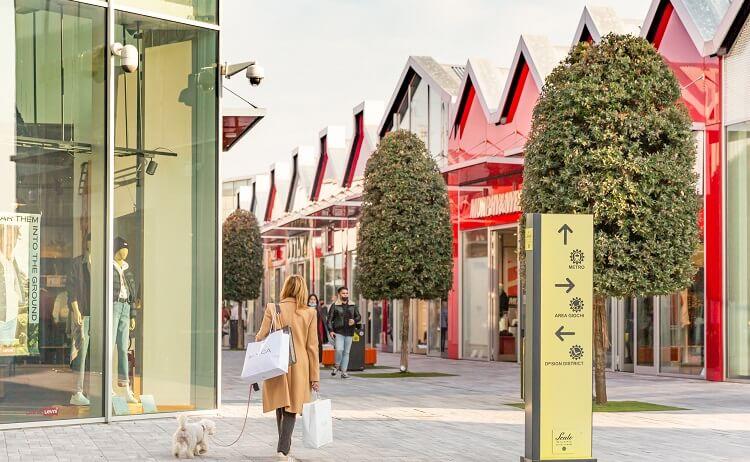 une femme fait du shopping dans un centre commercial avec son chien