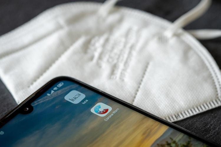 Masque et téléphone avec les applications luca et covidwarn