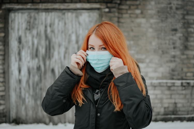femme rousse avec un masque contre le covid en Suède