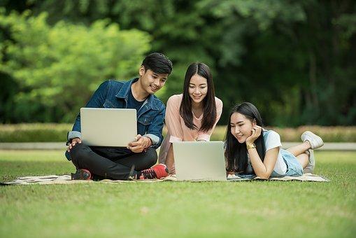 trois etudiants qui travaillent dans l'herbe