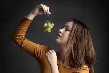 une jeune femme avec une grappe de raisins, en Espagne