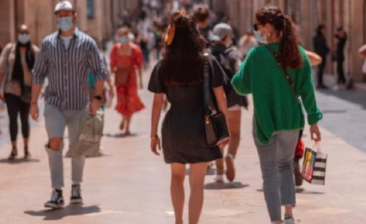 des filles marchent de dos dans la rue avec masques