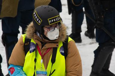 Un journaliste avec un casque et un masque