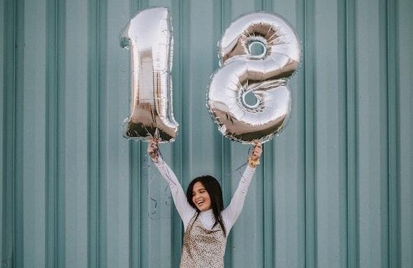 une Espagnole agite deux ballons avec la forme du chiffre 18
