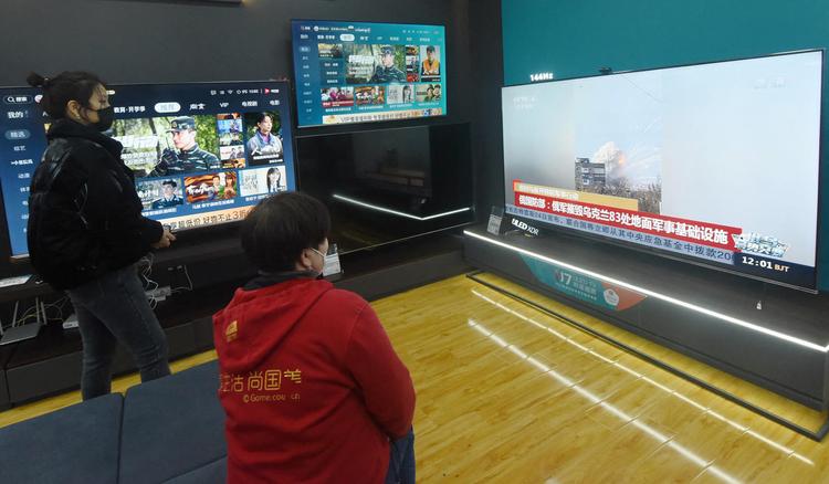 Des chinois regardent la télévision en Chine sur le conflir entre la Russie et l'Ukraine