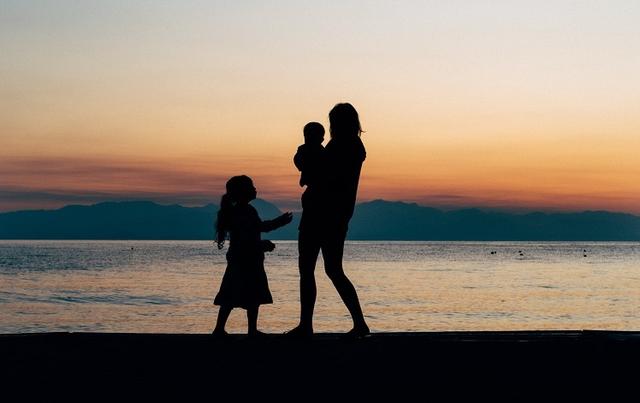 mère et deux enfants au coucher de soleil