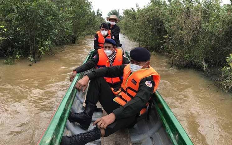 Des agents de la police militaire de Siem Reap patrouillent dans les eaux des forêts inondées du Tonle Sa, à la recherche de terres illégalement accaparées fin novembre. (GRK News)
